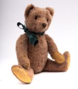 A mid 20th century brown mohair growler teddy bear probably Steiff, button missing, plastic eyes,