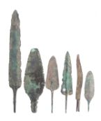 A group of five Bronze Age arrowheads and a Bronze Age razor.