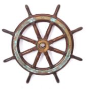 A teak and brass ship's helm, the central brass boss radiating block and turned spars,