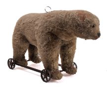 An early 20th century Steiff roll along growling bear, with boot button eyes,