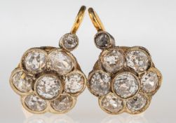 A pair of early 20th century diamond flower earrings, each of flowerhead form,