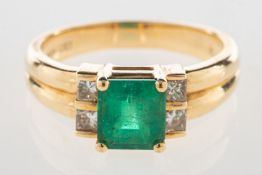 An emerald and diamond ring, claw set with a rectangular-cut emerald,