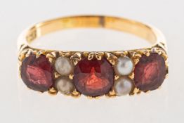 A garnet and pearl ring, set with three circular-cut garnets, interspaced by four split pearls,