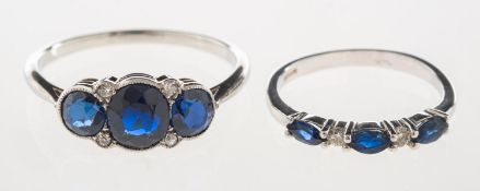 A group of two rings, including a ring set with three marquise-cut sapphires,