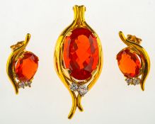 A fire opal and diamond pendant with matching earrings,