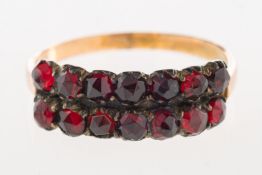 A Victorian Bohemian garnet ring, with two rows of faceted garnets, enclosed back setting, unmarked,