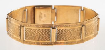 An Art Deco bracelet, made up of articulated rectangular links with engine turned engraving,
