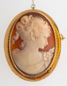 A cameo brooch with safety chain, a cameo of a female bust in a rope twist mount,
