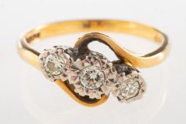 An 18ct gold three stone diamond twist ring, illusion set with three brilliant-cut diamonds,