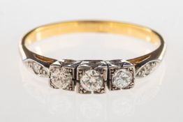 An Art Deco three stone diamond ring, set with three older-cut diamonds in a square setting,