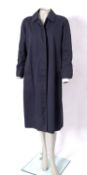 Burberry, London. A lady's navy blue cotton raincoat with waist belt.