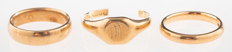 A group of three 9ct gold rings, including two wedding bands, both size J1/2,