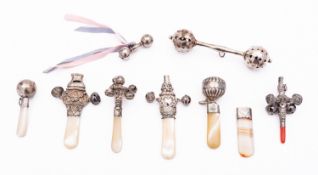 A mixed group of silver and mother of pearl baby rattles; including two dumb bell rattles,