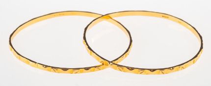 Two 18ct gold bangles, each with engraved design, one with UK hallmark and one with UK import mark,