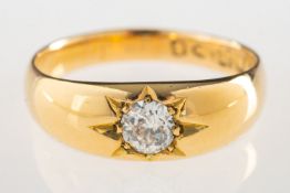 An 18ct gold antique diamond ring, gypsy set with an old-cut diamond, slightly off round in shape,