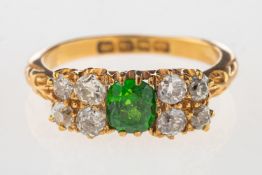An early 20th century 18ct gold ring, claw set to the centre with an oval-cut green stone,