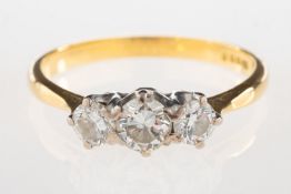 An 18ct gold three stone diamond ring, set with three graduated brilliant-cut diamonds,