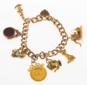 A charm bracelet and seven charms, the charm bracelet with heart padlock and safety chain,