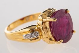 An 18ct gold ruby and diamond ring, claw set with an oval-cut ruby, approx. 4.