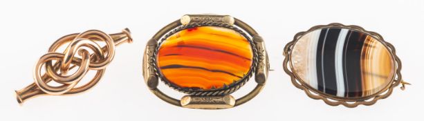 A group of three brooches, including two gilt framed agate set brooches,