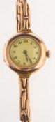 A small lady's vintage gold wristwatch the round cream dial having black and red Arabic numerals