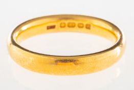 A 22ct gold wedding band, UK hallmark, size approx. M1/2 to N (slightly misshapen), 7.0grams.