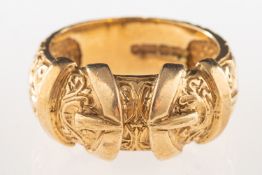 A 9ct gold buckle ring, an ornately carved buckle ring, UK import mark, size V, 11.1grams.
