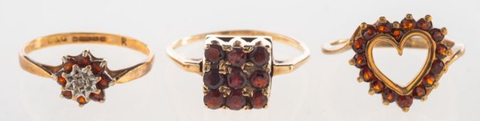 A group of three garnet set rings,