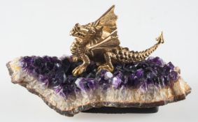 A 9ct gold model of a dragon sat atop a slice of amethyst geode,