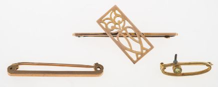 A group of three brooches, including a bar brooch with an openwork design depicting an owl,