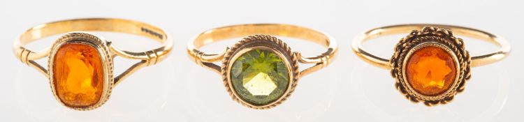 A group of three 9ct gold gem-set rings, including a 9ct gold ring set with an oval-cut fire opal,