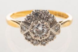 An 18ct gold diamond daisy ring, of flowerhead form and set with a central brilliant-cut diamond,