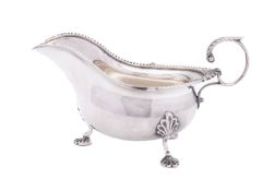 A George V silver sauce boat by Walker and Hall, Sheffield 1920, the gadrooned and shell rim,