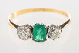 An emerald and diamond ring, set to the centre with an emerald-cut emerald,