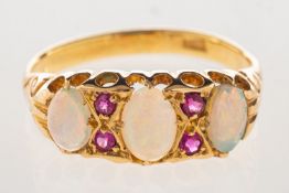 An opal and ruby ring, set with three opal cabochons, interspaced by four circular-cut rubies,