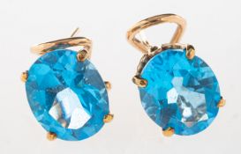 A pair of blue topaz earrings, each claw set with an oval mixed-cut blue topaz,