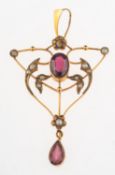 An Art Nouveau pendant, of openwork form and set to the centre with an oval-cut garnet,