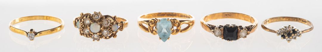 A group of five rings, including a 9ct gold ring set with three opal cabochons and paste stones,