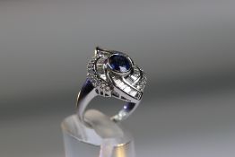 A contemporary Sapphire and Diamond Cluster Ring,the oval shaped central sapphire with rub over