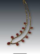 A Cabochon Ruby and Yellow Metal Fringe Necklace set to the front with eleven slightly graduated