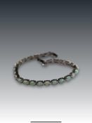 An Opal Like Bracelet composed of a single line of twenty six oval shaped claw set man-made opals on