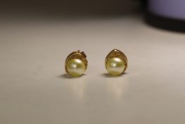 A Pair of Cultured Pearl and Diamond Earstuds,  The single stone cultured pearls within small