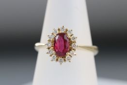 A pretty ruby and diamond cluster ring set in 14ct gold
