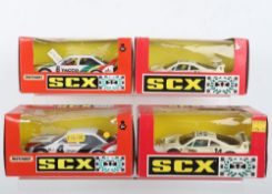 Four boxed SCX slot cars,
