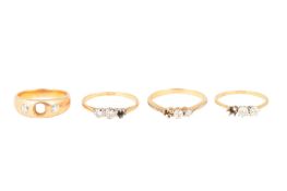 FOUR THREE-STONE DIAMOND RINGS