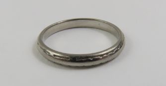 A lightly patterned wedding band, marked 'palladiu