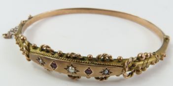 An early 20th century 9ct gold hinged bangle, the