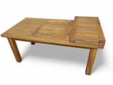 A modern oak extending dining table, on four block