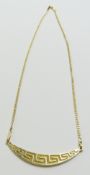 A gold necklace with a central Greek Key pattern d