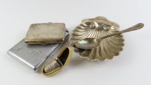A silver shell shaped dish, on three ball feet, a